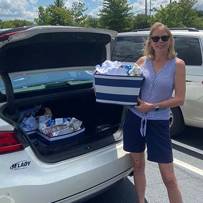 woman putting gift basket in trunk of car